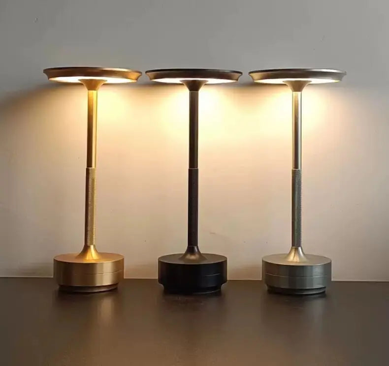 Three Orbit lamps glowing in gold, black and silver