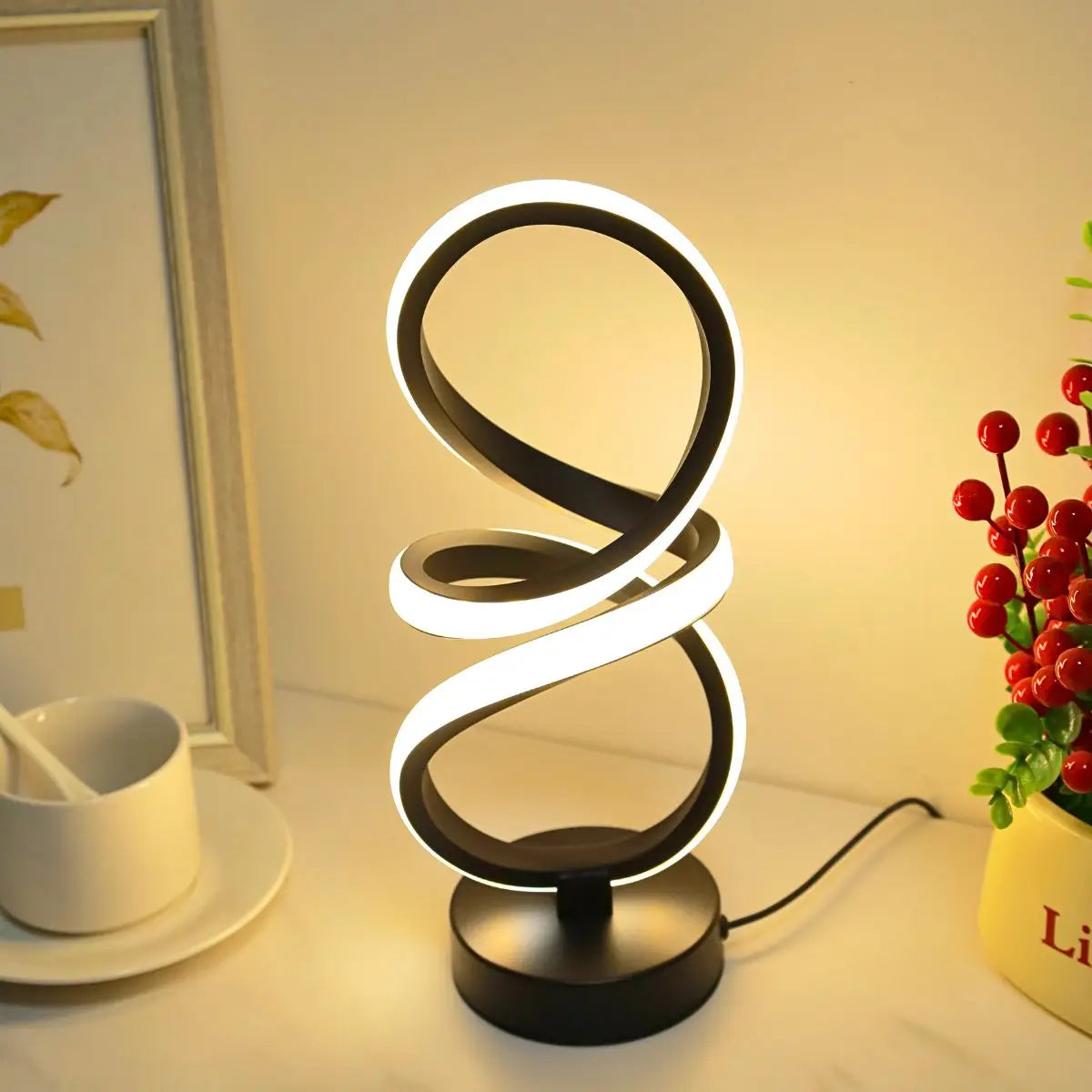 Loop Lamp in black glowing warm on a table