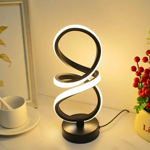 Loop Lamp in black glowing warm on a table