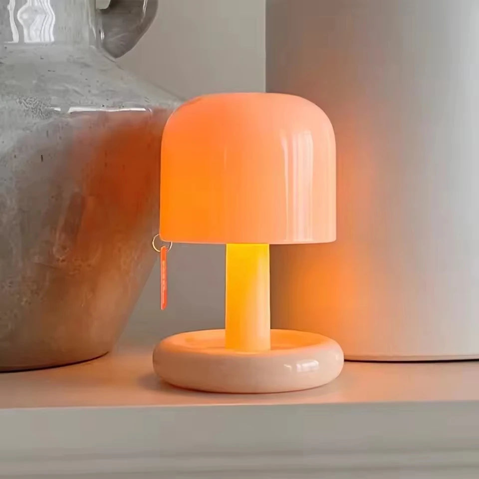 The Dusk Lamp glowing beside a vase